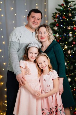 Baba, anne ve iki kız Noel ağacından önce. Aşk 