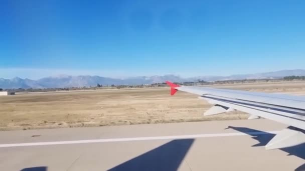 Крыло взлетевшего самолета в полете из окна самолета — стоковое видео