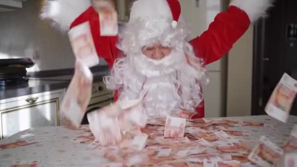 Santa claus gooit geld op thuis in de keuken. — Stockvideo