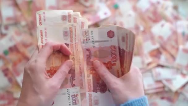 Vista superior. las manos de las mujeres cuentan billetes de cinco mil rublos. — Vídeos de Stock