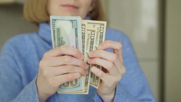 Gros plan. les femmes en pull bleu comptent les billets de banque de dollars. — Video
