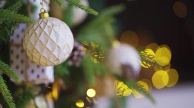 Noel ağacının dekore edilmiş dalları arka plandaki çelenk ampullerine karşı.