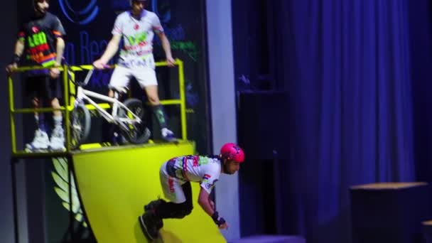 Cámara lenta. patinadores de ruedas realiza acrobacias en el escenario en los hoteles — Vídeos de Stock