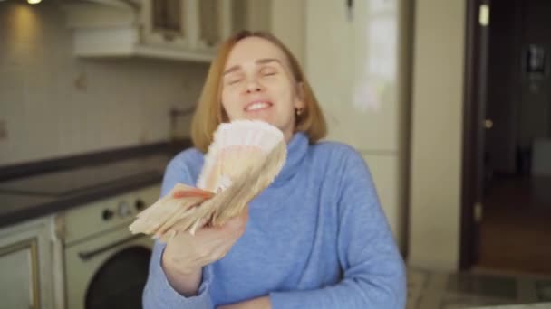 Жінка-вболівальник, наповнена великою стопкою рублів вдома на кухні . — стокове відео