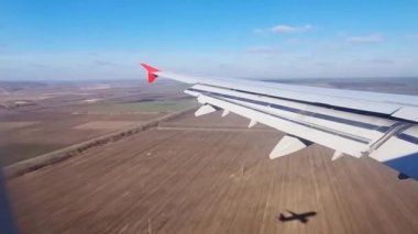 Uçan uçağın kanadı uçağın penceresinden uçuyor. 