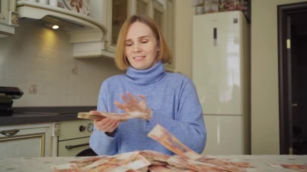 Μια γυναίκα πετάει λεφτά στο σπίτι στην κουζίνα.. — Αρχείο Βίντεο