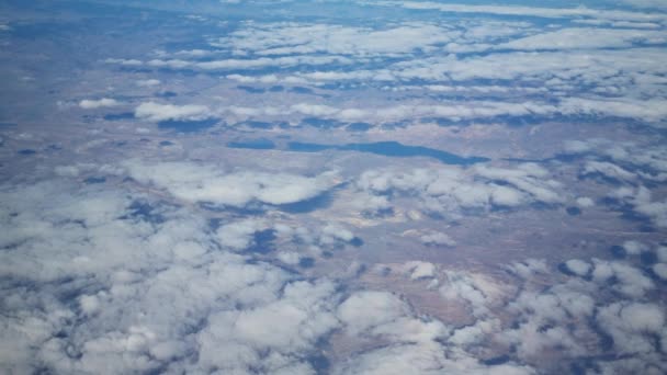 Kilátás a repülőgép ablakából a felhőkre és a földre. — Stock videók