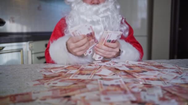 Santa claus cuenta rápidamente el dinero en casa en la cocina — Vídeos de Stock