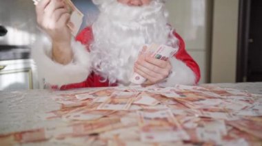 Noel Baba evde mutfakta yavaş yavaş para sayıyor.