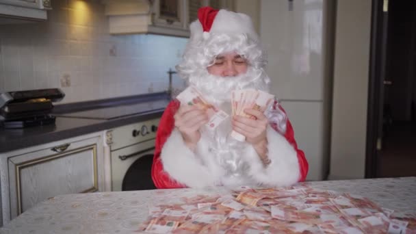 Weihnachtsmann zählt zu Hause in der Küche Geld — Stockvideo