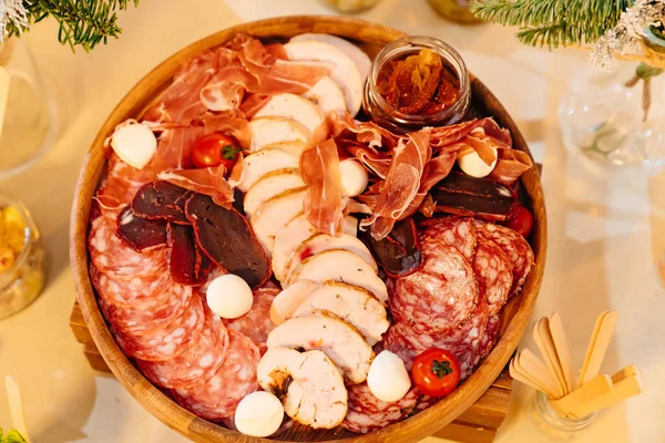 Widok z góry. zimne kawałki na okrągłym drewnianym talerzu z serem i pomidorami. — Zdjęcie stockowe