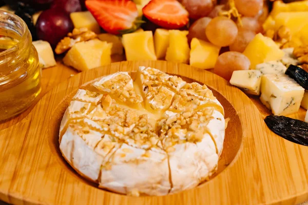 Camembert. wooden tray with cheese, fruit and honey. — Stock Photo, Image