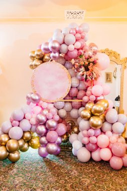 Doğum gününü kutlamak için pembe balonlar ve çiçeklerle dolu bir fotoğraf bölgesi..