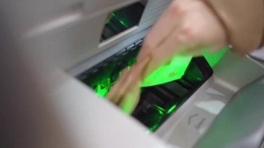 Bir kadının eli hesabı tazelemek için bankamatiğe para yatırır..