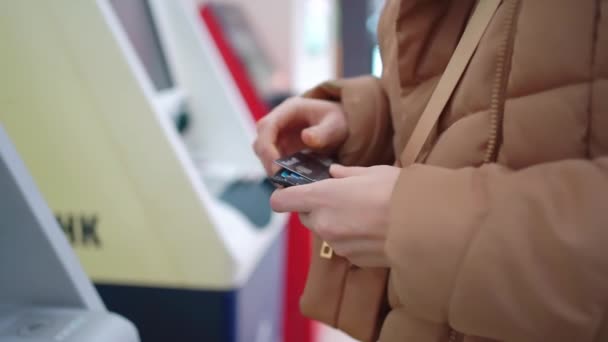 As mãos das mulheres colocam o cartão de crédito no atm. — Vídeo de Stock