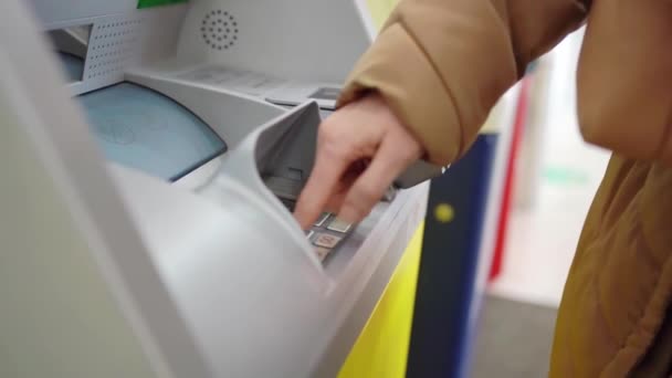Uma mão digite o código do pino ou montante no teclado ATM para retirar dinheiro do cartão. — Vídeo de Stock
