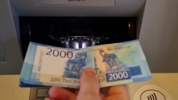 Una mano de hombre coloca billetes en un receptor de cajero automático. 2000 — Vídeo de stock