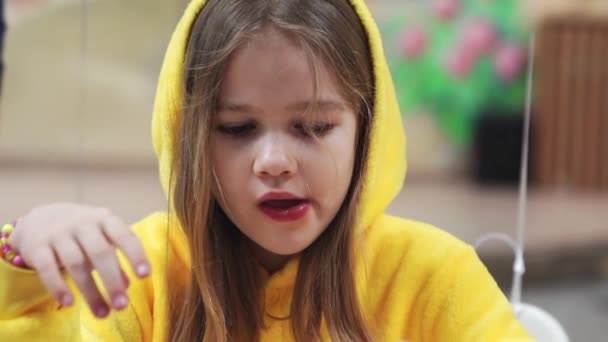 Sarı kapüşonlu tatlı küçük kız bir dilim pizza yiyor.. — Stok video