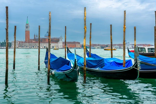 2 Aralık 2021 - Venedik, İtalya: Gondollar arka planda Chiesa di San Giorgio Maggiore ile Grand Canal 'daki Sam Marco Gondola Servis İstasyonu' na demirlediler.