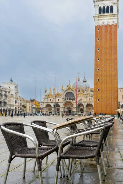 2 Aralık 2021 - Venedik, İtalya: Arka planda bazilikası ve çan kulesi olan Piazza San Marco 'daki açık kafe.