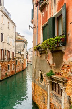 2 Aralık 2021 - Venedik, İtalya: Binalar arasında akan dar kanal manzarası.