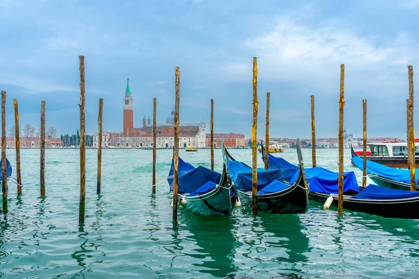 2 Aralık 2021 - Venedik, İtalya: Gondollar arka planda Chiesa di San Giorgio Maggiore ile Grand Canal 'daki San Marco Gondola Servis İstasyonu' na demirlediler.
