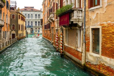 2 Aralık 2021 - Venedik, İtalya: Evler arasındaki dar kanal boyunca seyreden bir sürat teknesi.