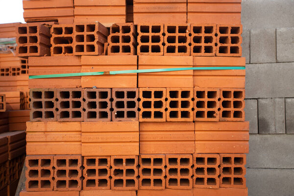 pile of red perforated brick blocks for building construction
