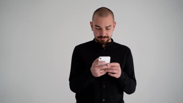 Jeune Beau Barbu Chemise Noire Sur Fond Blanc Tient Téléphone — Video