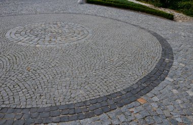 Küçük bir parke küpünün içinde büyük, koyu gri bir daire olan kare. Taş granit ve bazalt. Şehrin tarihi merkezinde arabaların ve limuzinlerin döndüğü bir onur mahkemesi.