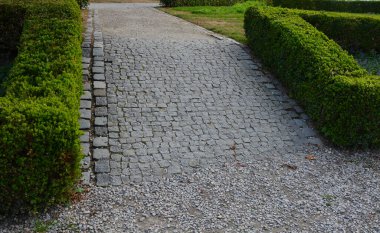 Boxwood çitleri olan yaz şatosu parterre dürüstçe budanmış, yolu bej sıkıştırılmış çakıl yolu boyunca uzanır. Boxwood 'un şekli de güzel, içinde uzun ömürlü mavi bir örtü var.