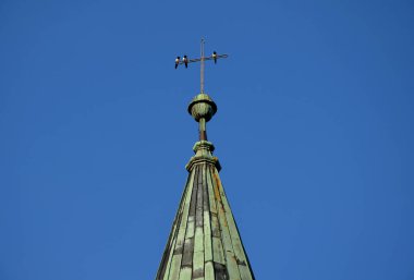 Kilisenin çarmıhında, bakır yeşil kaplama kulesinde altın, mücevher ve parlak nesneleri seven aynı üç kuş oturuyor. insan çalmak, saksağan, beyaz-siyah yırtıcı