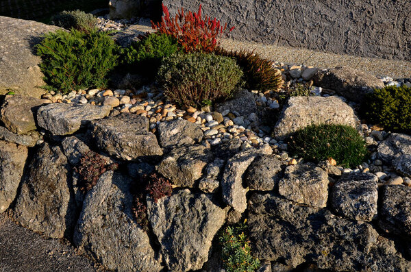 dry gray wall, folded boulders without the use of cement. the art of folded retaining walls. very colorful rock gardens like the rocky environment. garden architecture