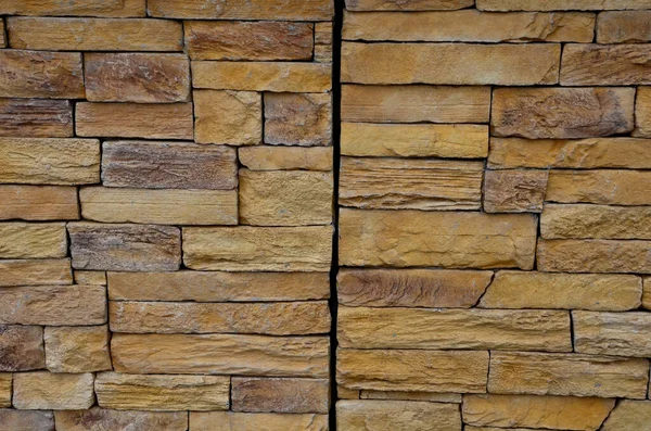 stone wall made of regular sandstone cladding. roughly hewn boards with a hidden lamp to the wall surface. it shines under the feet of pedestrians so that they do not trip over the night journey