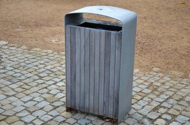 kırmızı sandalyeler, yuvarlak masalar ve kaldırımlı bir meydanda kum yüzeyi sıkıştırılmış çakıllar. Buz kreması. Ziyaretçiler ve turistler için koyu gri su içicisi. Ahşap kaplı çöp kutusu.