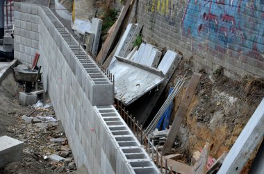 Köprü başındaki çirkin çentikler. Beton katmanlı ve drenajlı istinat duvarı. Kablolar, korkuluklar, temeller ve eski çirkin sanayi bölgesini kaplayan içi boş tuğlalarla dolu bir çit.