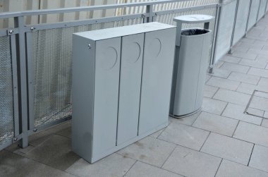 Üç parça atık için gri atık kutusu, karede, platformda kağıt, plastik ve cam ayrımı için üç delik. Parlak kiremitlerdeki çöp kutusu