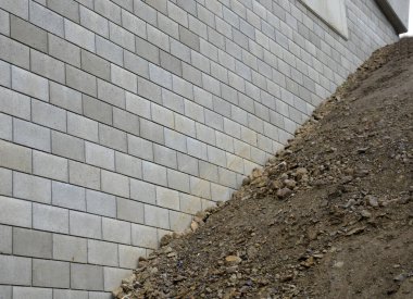 Köprü başındaki çirkin çentikler. Beton tuğlalarla dolu istinat duvarı. Üst toprağı olan bir yamaçta çapraz gömülü. Rayların ve otoyolun yüksek eğimli setlerinin peyzajı