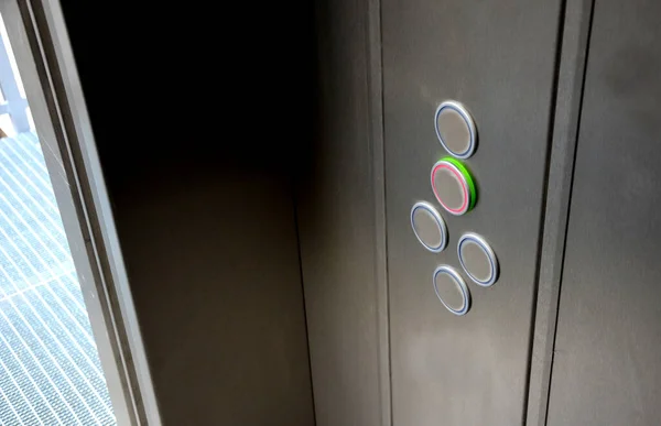 exit from the stainless steel elevator car. The elevator is equipped with a folding seat. when opened you can see the lattice, mesh floor and balcony railings.