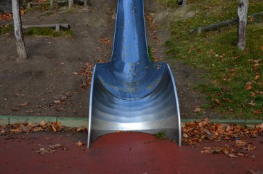 Çimenli tepeler ve ahşap çayırları olan paslanmaz çelik kaydırak. Tartan kauçuk pede çarpan kaygan çocuklar için büyük parlak bir tüp. Tüpün ucu açık bir yalaktır.