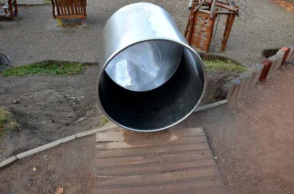 Çimenli tepeler ve ahşap çayırları olan paslanmaz çelik kaydırak. Tartan kauçuk pede çarpan kaygan çocuklar için büyük parlak bir tüp. Tüpün ucu açık bir yalaktır.