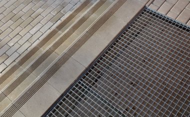 Kayma önleyici kanalları olan beton merdivenler. Merdivenlerin yanında evin girişinde tekerlekli sandalyeler için bir rampa var. Kiremitlerdeki bir teneffüste ayakkabıları temizlemek için metal şebeke