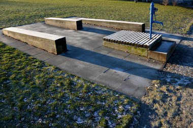 Mavi metal retro, parlak ahşap kapaklı. Su el pompasından taş yalağa akar. Bahçe tezgahı şekilli prizma çimenlik park mimarisi, dayanıklılık, ucuz