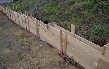 Beton çitin temelini atmadan önce ahşap bir yapı inşa edilir. Duvarın tabanını güçlendirmek için içine beton kablolar yığılmış..