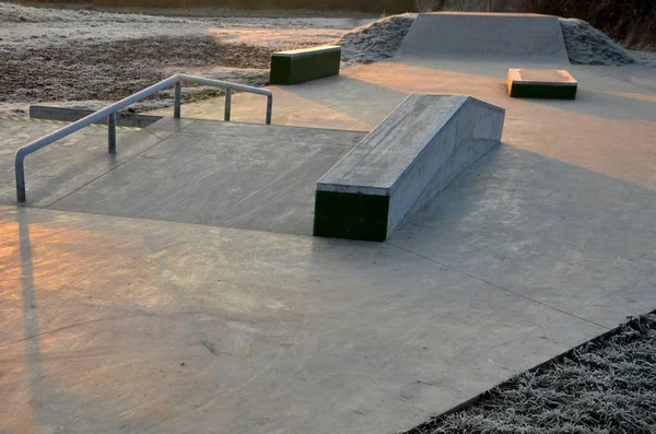 滑板公园的混凝土水泥表面与混凝土滑板的障碍是为滚动运动设计的 除了自由式自行车外 不允许骑自行车 寒冷的冬日日出 — 图库照片