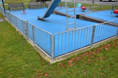 Paslanmaz çelik sürgülü oyun alanı, mavi kauçuk yüzey. Devasa kirişlerle çevrili teraslar. Kapısı köpeklere karşı olan galvanize çitler. Kırmızı salıncaklar çelik yay arka bahçesinde kreş plastiği