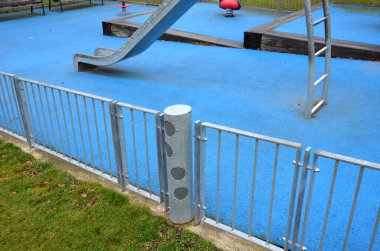 Paslanmaz çelik sürgülü oyun alanı, mavi kauçuk yüzey. Devasa kirişlerle çevrili teraslar. Kapısı köpeklere karşı olan galvanize çitler. Kırmızı salıncaklar çelik yay arka bahçesinde kreş plastiği