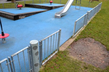 Paslanmaz çelik sürgülü oyun alanı, mavi kauçuk yüzey. Devasa kirişlerle çevrili teraslar. Kapısı köpeklere karşı olan galvanize çitler. Kırmızı salıncaklar çelik yay arka bahçesinde kreş plastiği