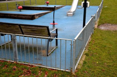 Paslanmaz çelik sürgülü oyun alanı, mavi kauçuk yüzey. Devasa kirişlerle çevrili teraslar. Kapısı köpeklere karşı olan galvanize çitler. Kırmızı salıncaklar çelik yay arka bahçesinde kreş plastiği