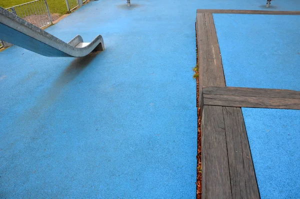 带不锈钢滑块的运动场 蓝色橡胶表面 与大梁相邻的梯田 镀锌栅栏 大门与狗抗衡 钢弹簧后院的红色摇摆板 — 图库照片